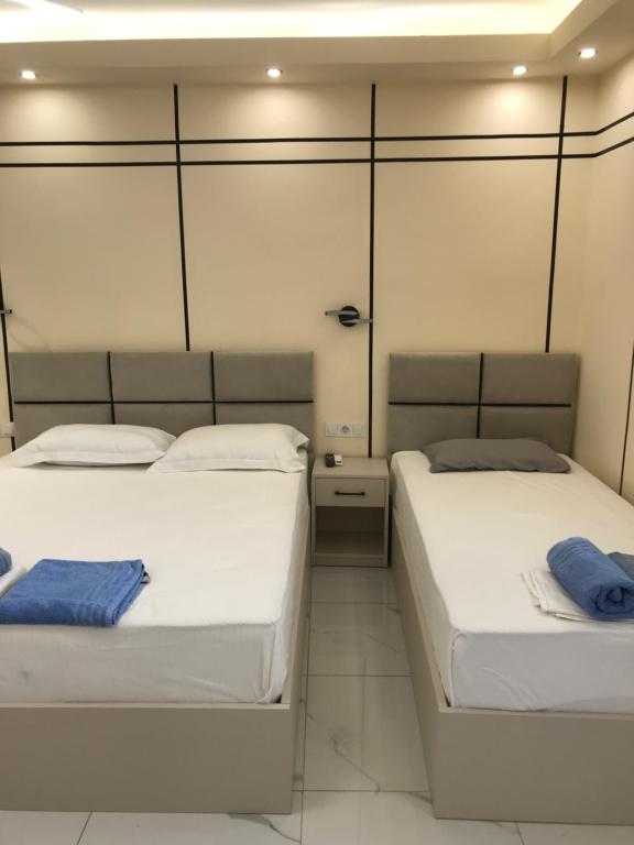 two beds in a room with two blue towels on them at Drenos Rooms view in Kallithea Halkidikis