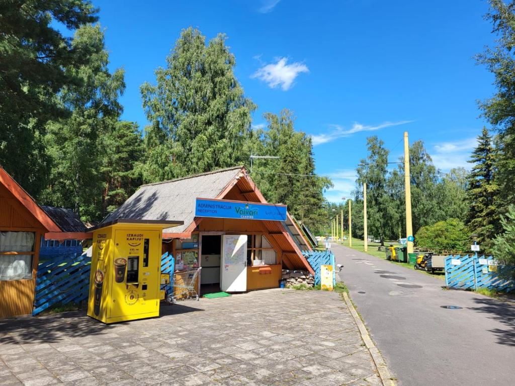 ein Laden in einem gelben Gebäude am Straßenrand in der Unterkunft Camping Vaivari Jūrmala in Jūrmala