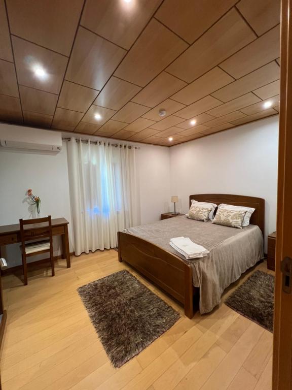 a bedroom with a bed and a desk in a room at Casa do Telheiro in Sabugueiro