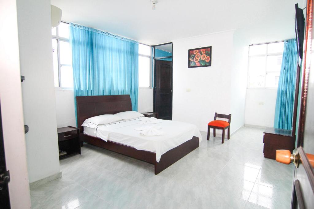 1 dormitorio con 1 cama y 1 silla en Hotel Ariari Azul, en Villavicencio