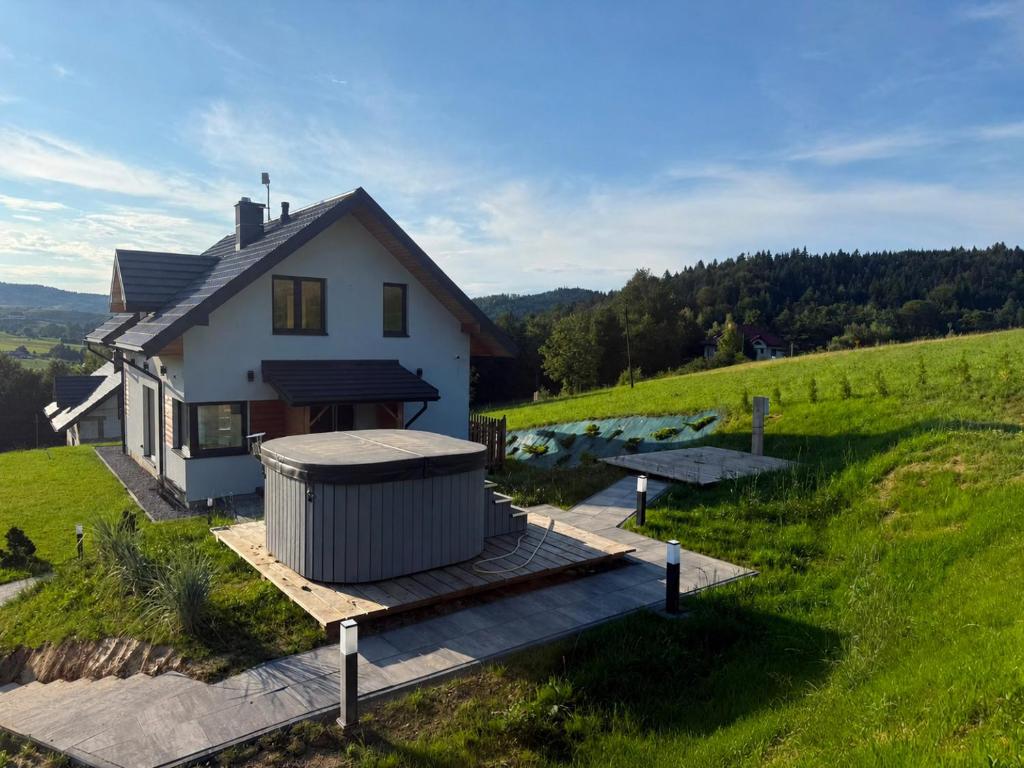 a house with a gazebo next to a field at Widokówka in Baligród
