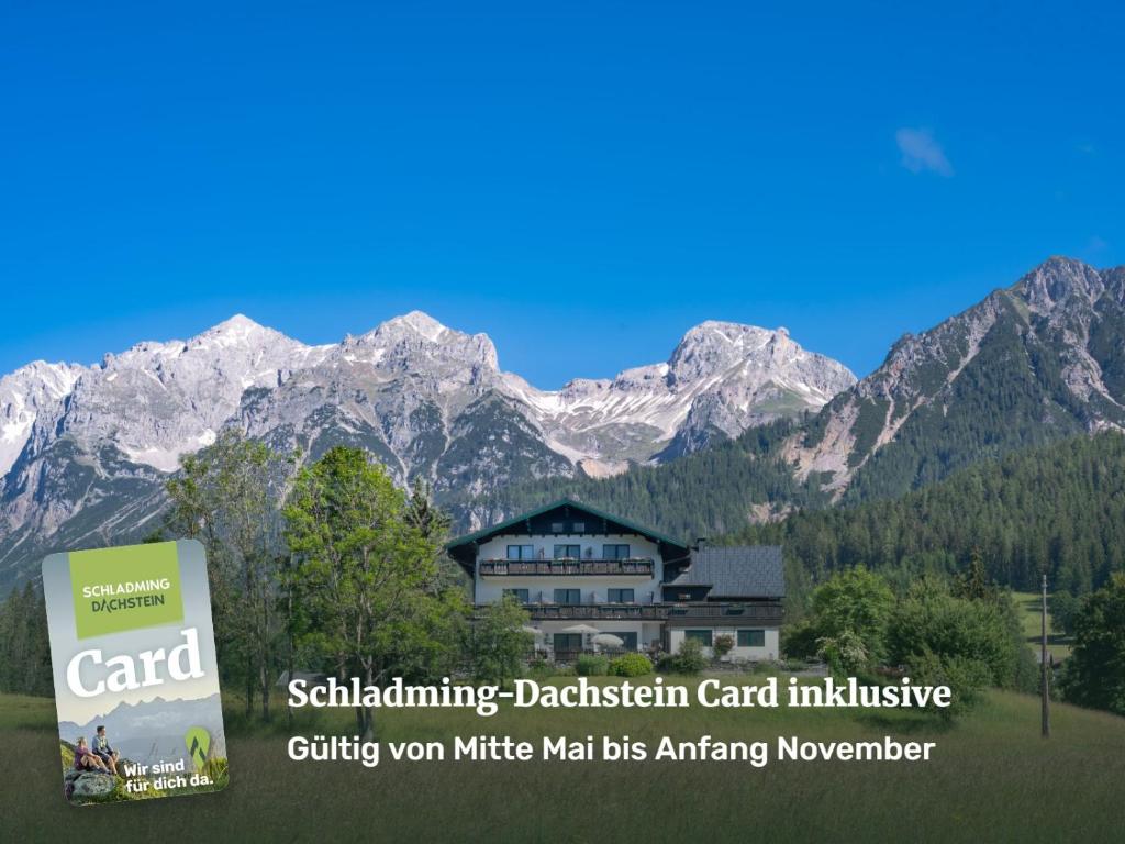 a building with a sign in front of a mountain at Sonnenhügel in Ramsau am Dachstein