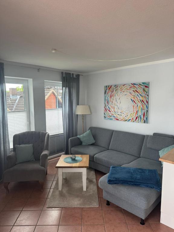 a living room with a couch and chairs and a table at Möwennest 13 Scharbeutz in Scharbeutz