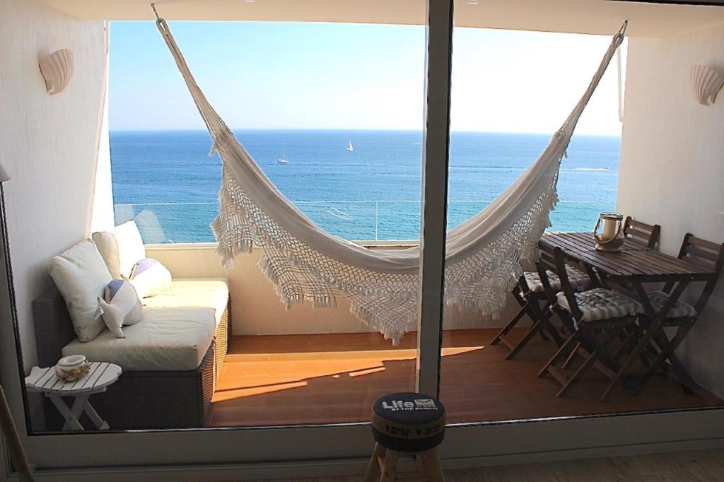 eine Hängematte in einem Zimmer mit Meerblick in der Unterkunft Akisol Sesimbra Beach II in Sesimbra