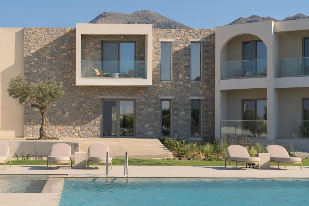 a villa with a swimming pool in front of a building at Fata Morgana Studios & Apartments in Frangokastello