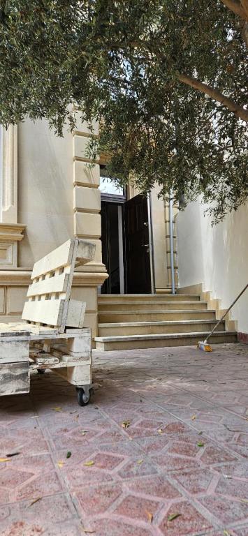 a wooden bench sitting in front of a building at Casa Villa in Baku