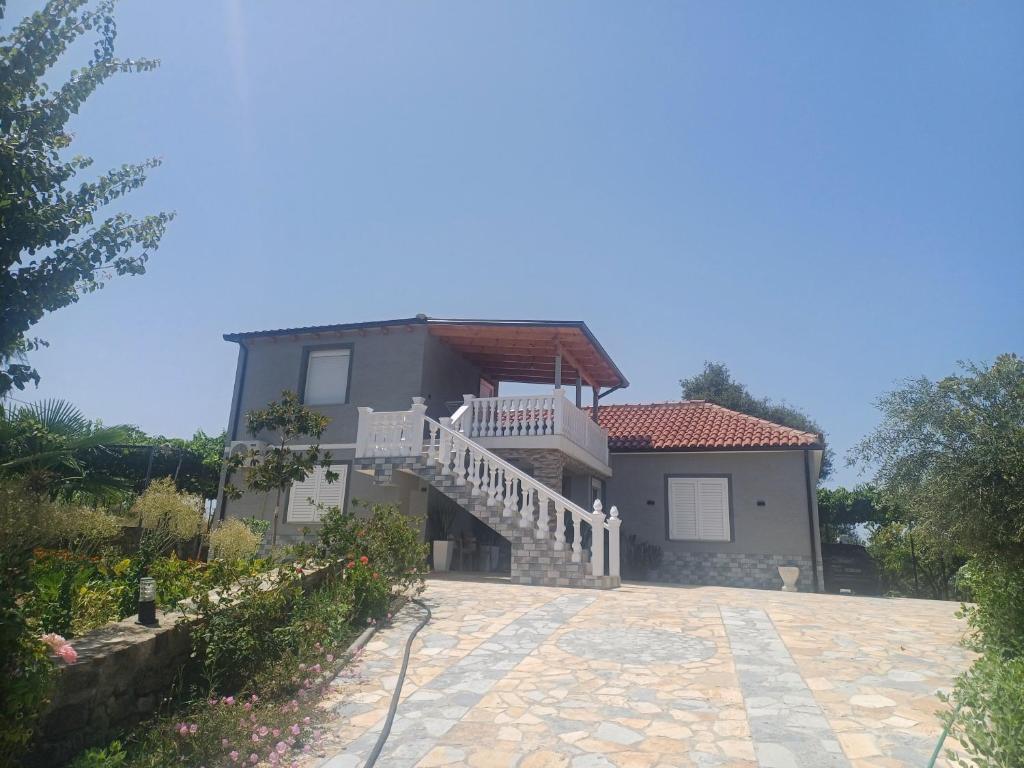 a house with a staircase in front of it at Hamit House Vacation in Fier