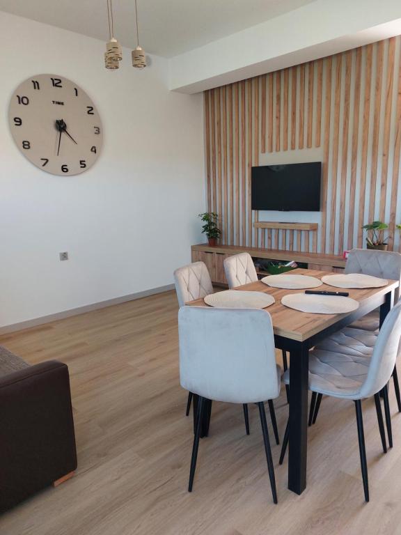 a dining room with a table and a clock on the wall at Nowy Zakątek in Paszkówka