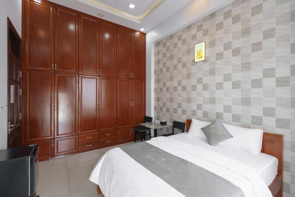 a bedroom with a large bed and wooden cabinets at Hotel TRUNG LÀI in Tây Ninh