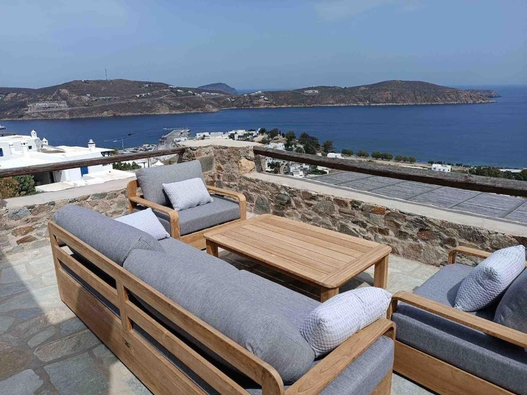 a patio with chairs and a table and a view of the ocean at Serifos View in Serifos Chora