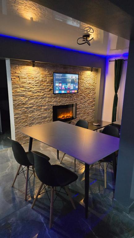 a table and chairs in a room with a fireplace at Divine House Straja in Lupeni