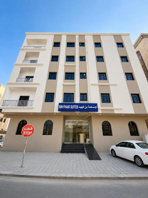 a white car parked in front of a building at Bin Fhaid Suites in Salalah