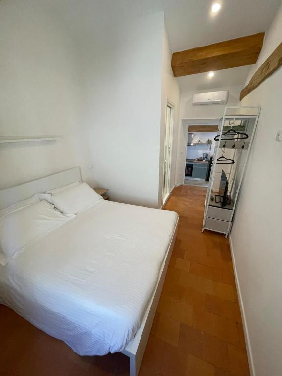 a small bedroom with a white bed and a mirror at SH Suite OLMO AC e Wi-Fi in Manziana