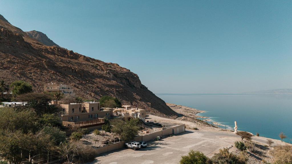 a group of houses on a hill next to the water at SPNI Ein Gedi Field School in Ein Gedi