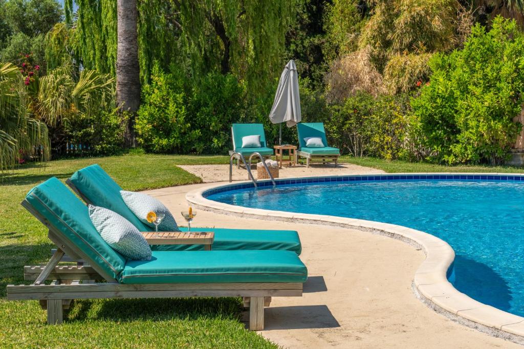 a swimming pool with two lounge chairs next to it at Gaia Residence in Argostoli