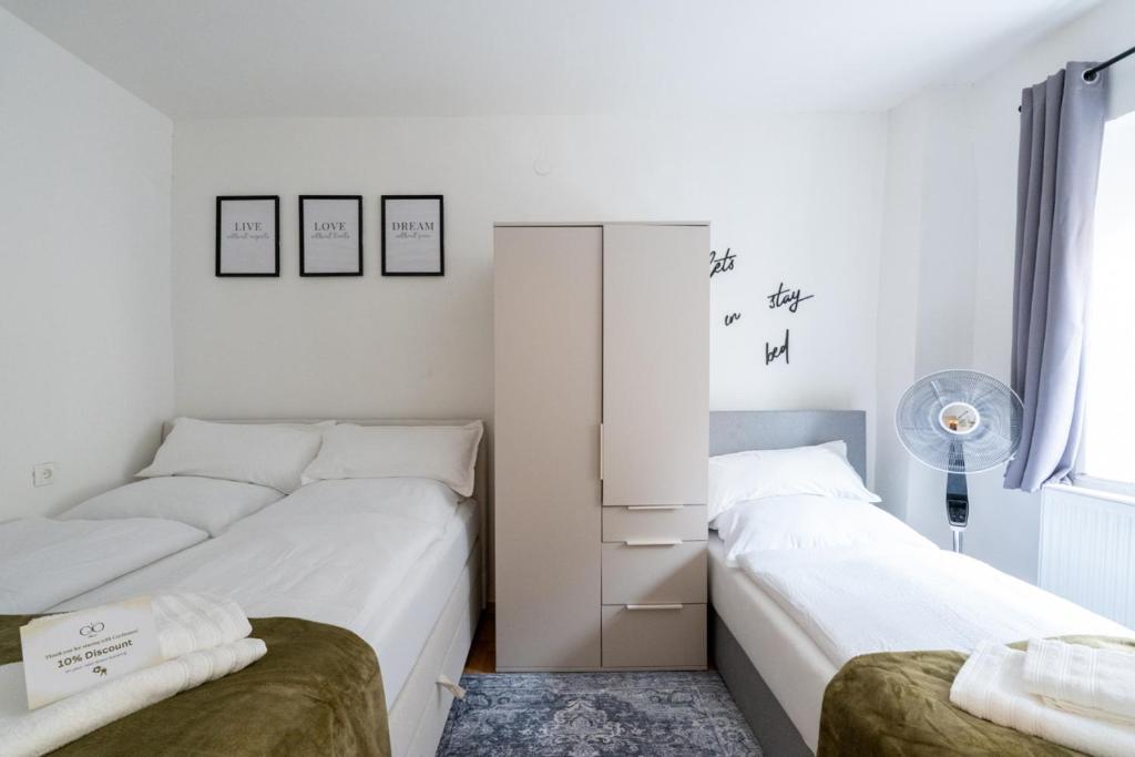 a bedroom with two beds and a closet at COY Apartments Kapfenberg - Spacious Stays for Companies, Groups & Workers in Kapfenberg