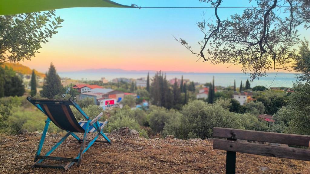 a blue chair sitting on a hill next to a bench at Camping Himara in Himare