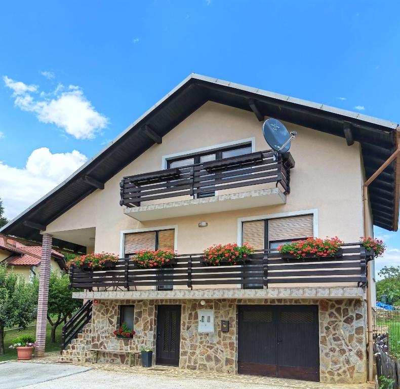 a house with a balcony with flowers on it at KaTi Hiša in Koble
