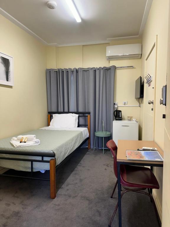 a room with a bed and a desk and a table at Workforce Accommodation in Kalgoorlie
