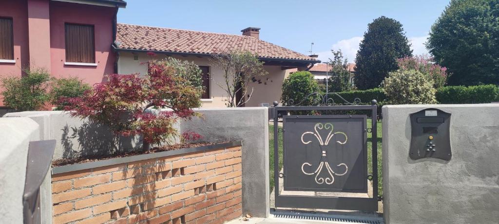 a fence with a gate with an entrance to a house at RAMERAHouse in Mareno di Piave
