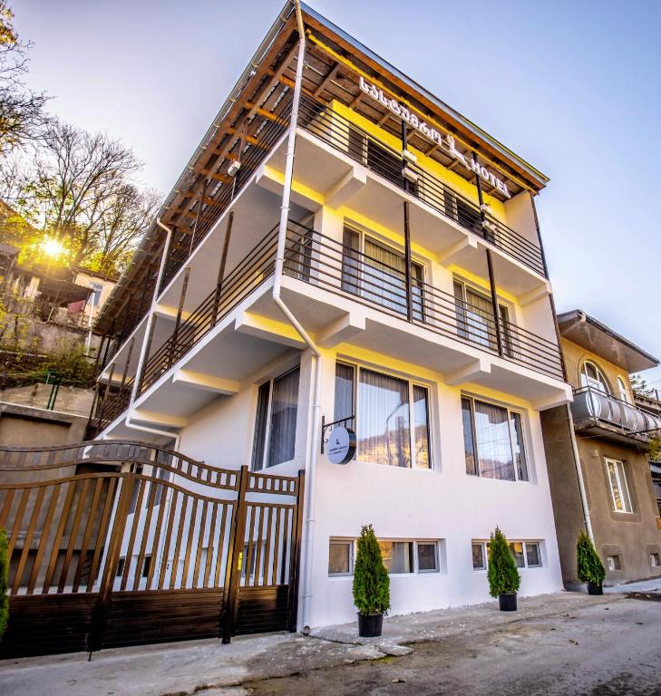 a large white house with a balcony at Hotel Caucasus Borjomi in Borjomi