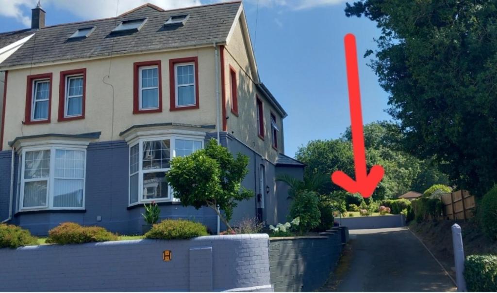 a house with a red arrow in front of it at Ty Castell Guest House in Caerphilly