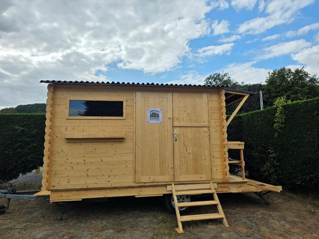 a wooden tiny house on a trailer with a ladder at Ardennen Karreke in Durbuy