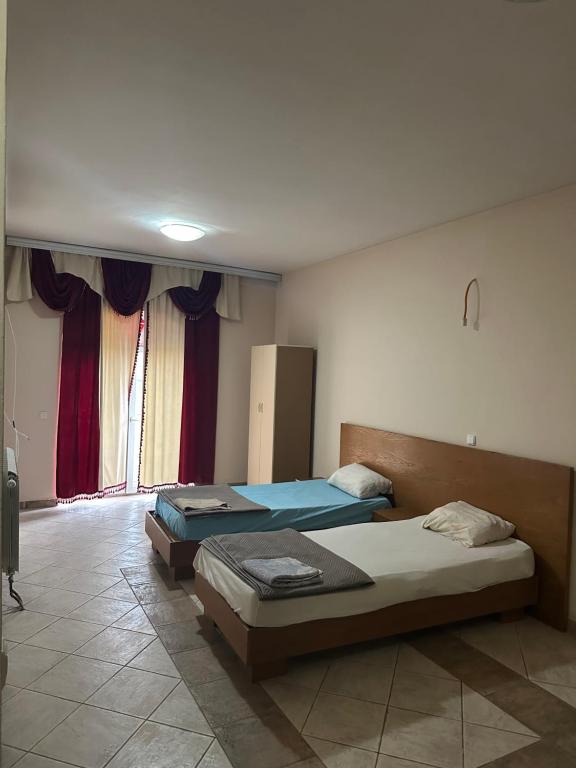 two beds in a room with a window at Kosvegas apartment 10 in Kosovo Polje