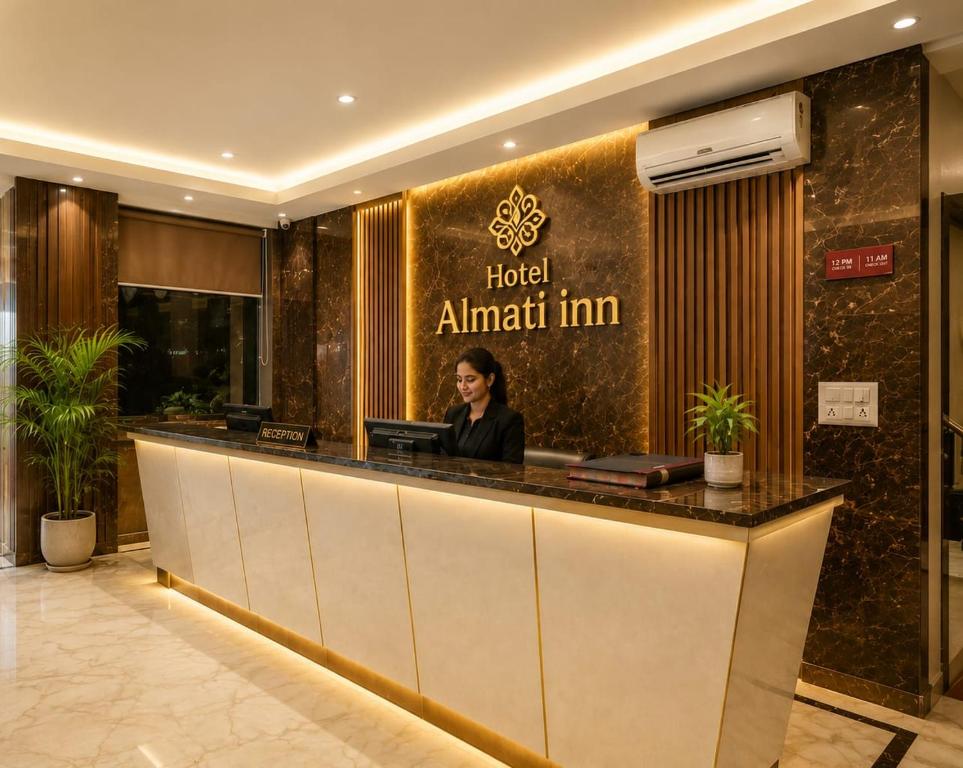 a woman sitting at a hotel counter in a lobby at Hotel Almati Inn Near IGI Delhi Airport - With Free Airport Pickup in New Delhi
