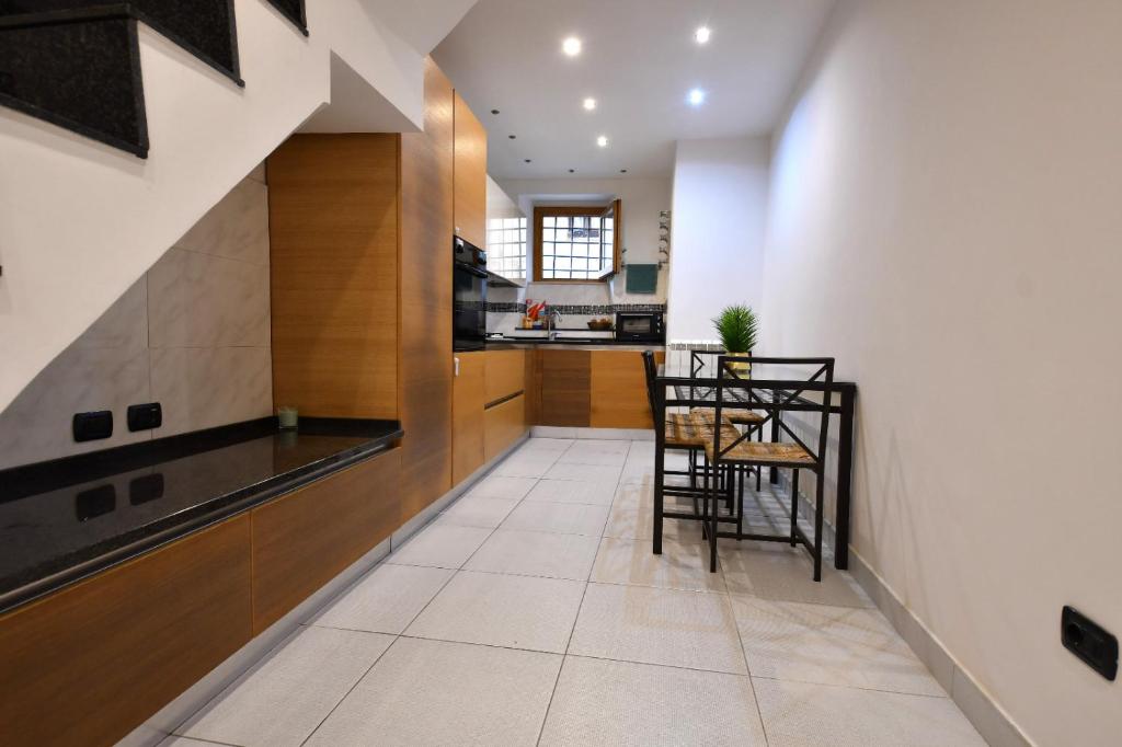a kitchen with a counter and a table and chairs at La Casa nel Borgo, a 20 minuti da Roma, relax e comfort con tutte le dotazioni, WiFi free in Monterotondo