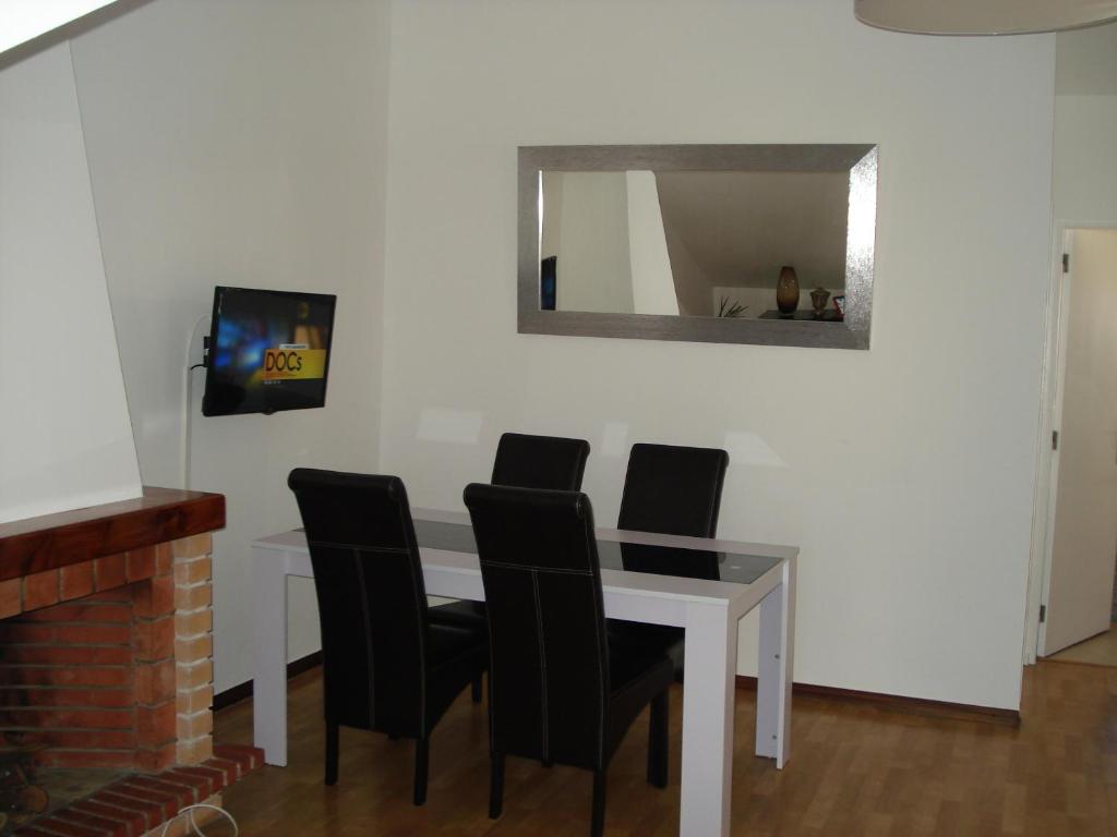 a dining room table with black chairs and a mirror at Belen Center Riverview in Lisbon
