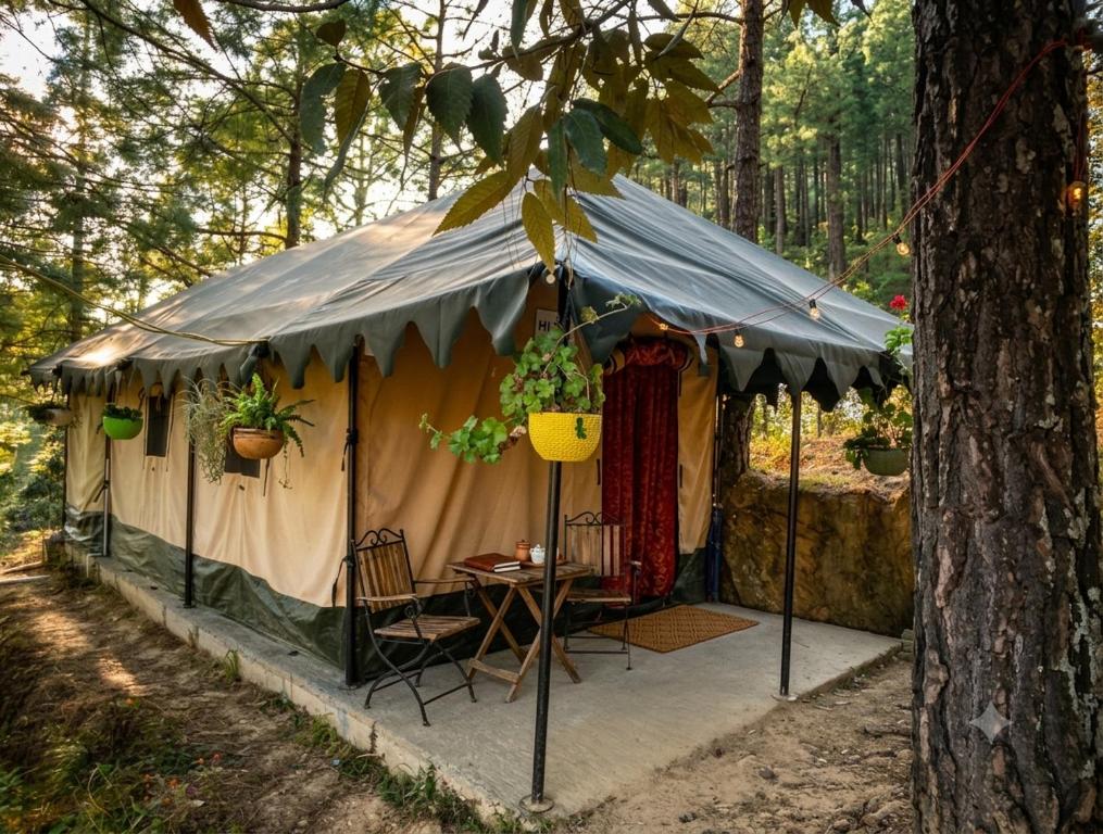 a tent with a table and chairs in a forest at Echoes in the Hills in Mukteshwar