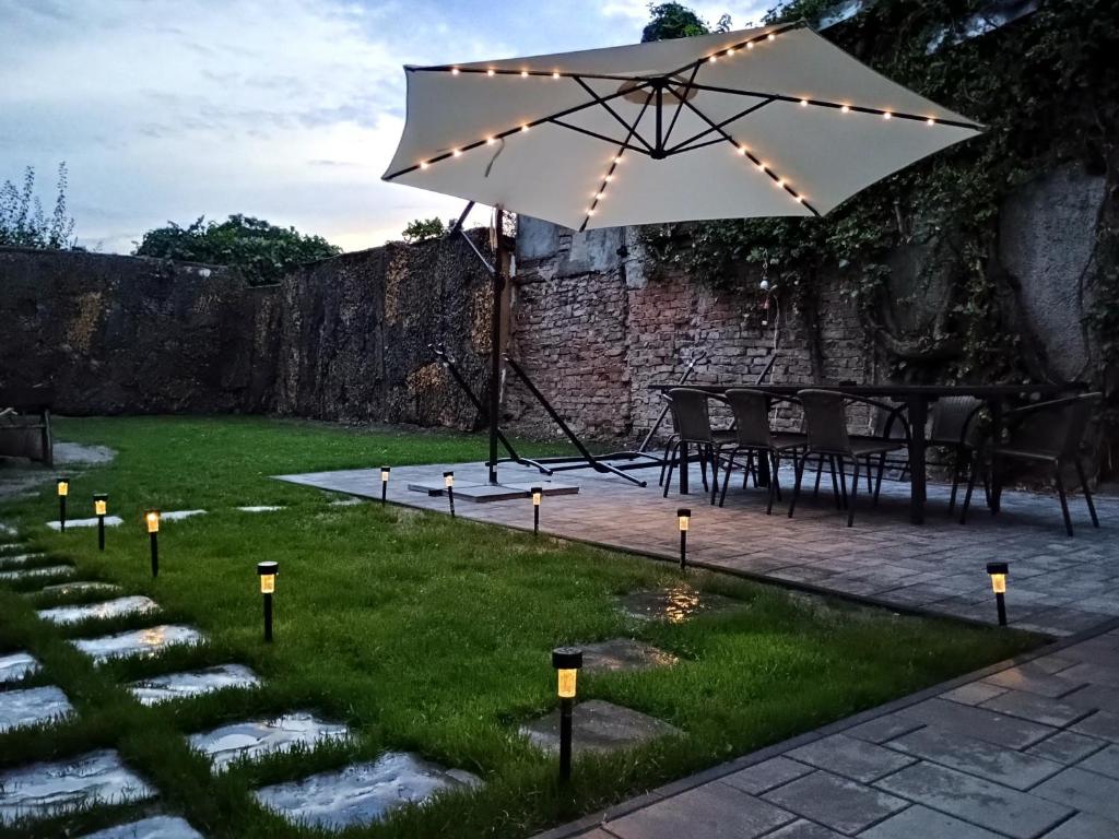 a patio with an umbrella and lights on the grass at Casa Rahova - centru civic in Brăila