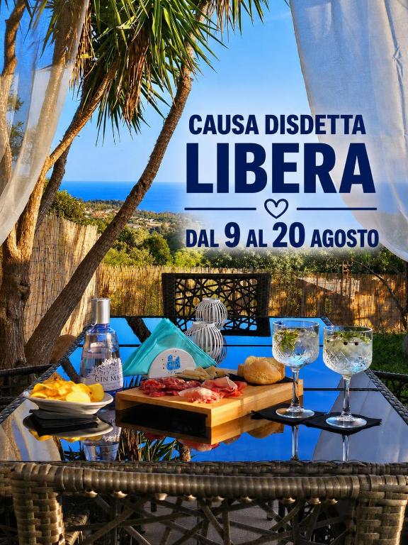 a table with food and wine glasses on a beach at Villa Mary Holiday Home Near Villasimius in Quartu SantʼElena