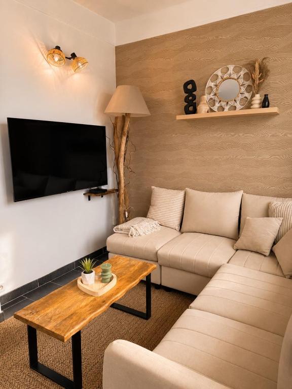 a living room with a couch and a flat screen tv at L'éclat du phare in Calais
