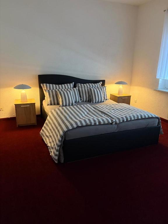 a bedroom with a large bed with two lamps at Apartments Zur Eiche in Großräschen