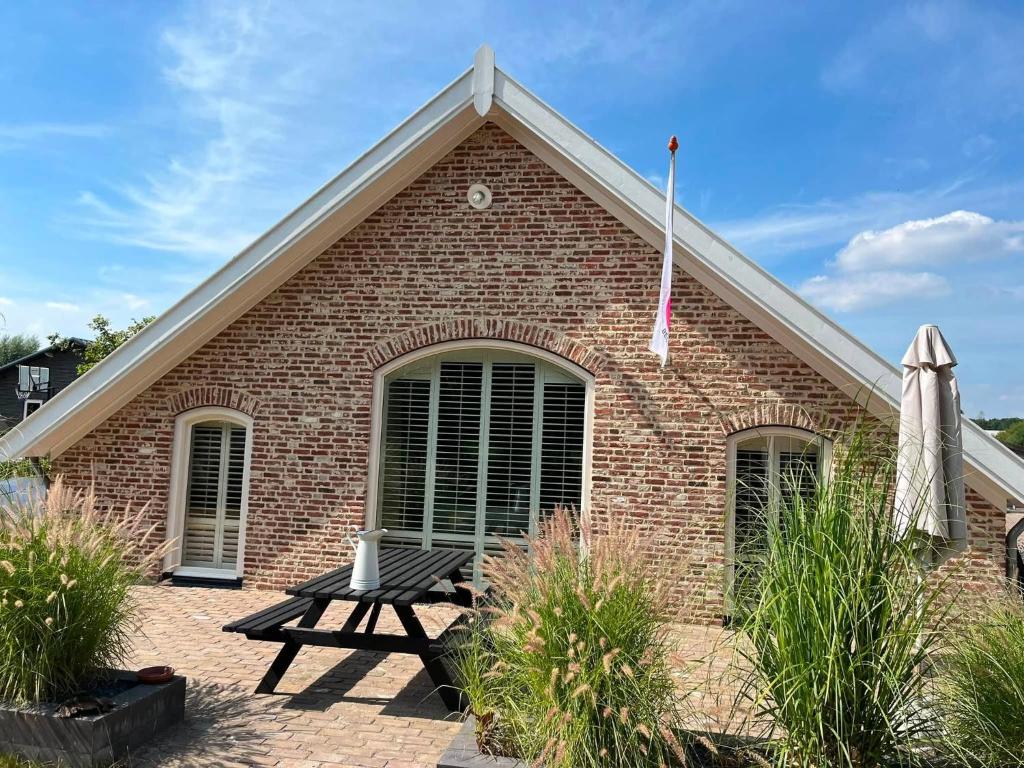 a brick building with a picnic table in front of it at B&B De Cootjes in Ossendrecht