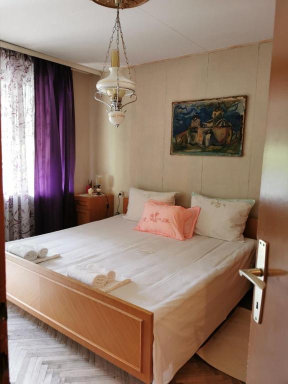 a bedroom with a large bed with white sheets and pink pillows at Apartman Ex-Yu in Španjola