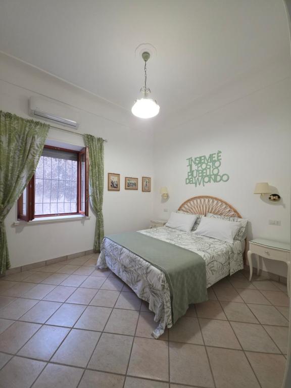a bedroom with a large bed and a window at 2Steps Capri - central holiday house in Capri