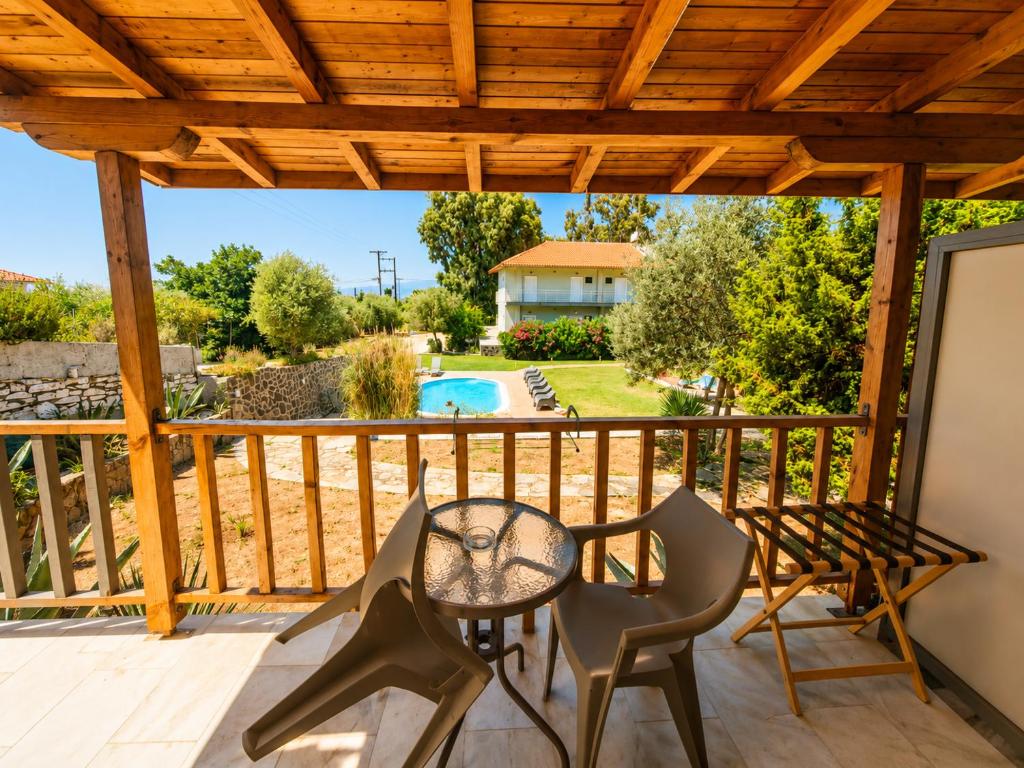 eine Terrasse mit Tisch und Stühlen auf einem Deck in der Unterkunft Hotel Marti Studios in Skala Sotiros
