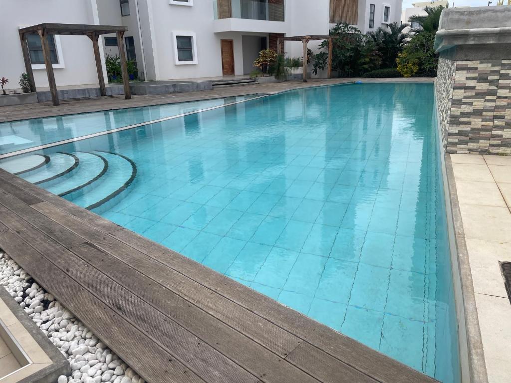 a swimming pool with blue water in a building at Le Frangipanier - Appartement de luxe 3 chambres, 3 sdb, Péreybère in Pereybere