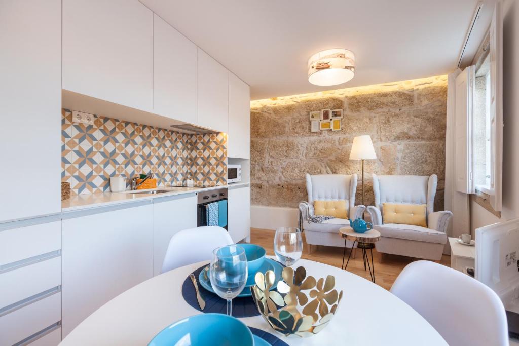 uma cozinha e sala de estar com mesa e cadeiras em Sendme2Portugal: Loureiro no Porto