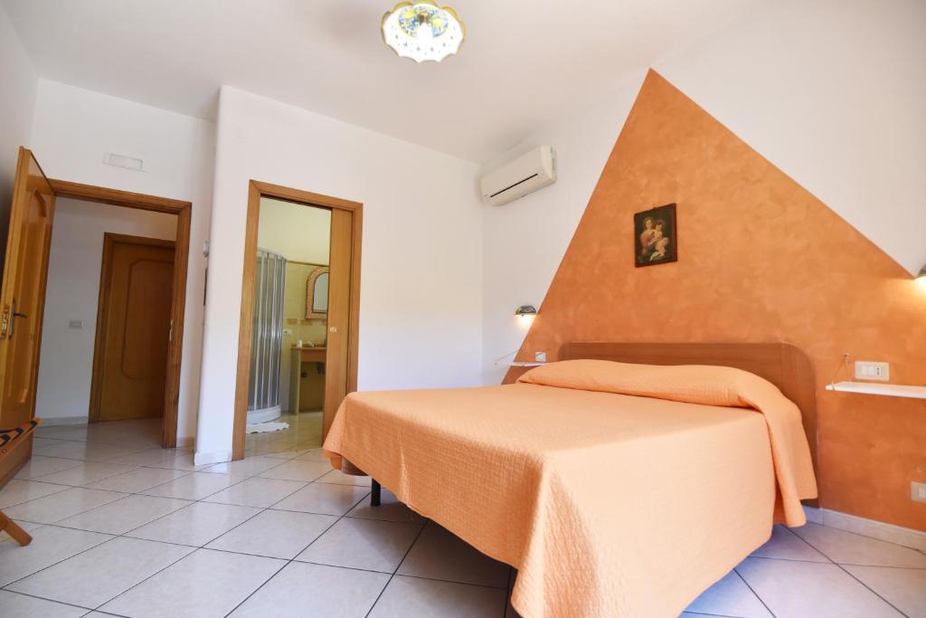a bedroom with a bed with an orange blanket at Haidi House in Agerola