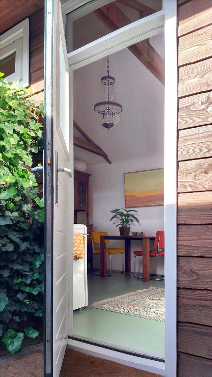an open door to a dining room with a table at Klein huisje in het centrum in Apeldoorn