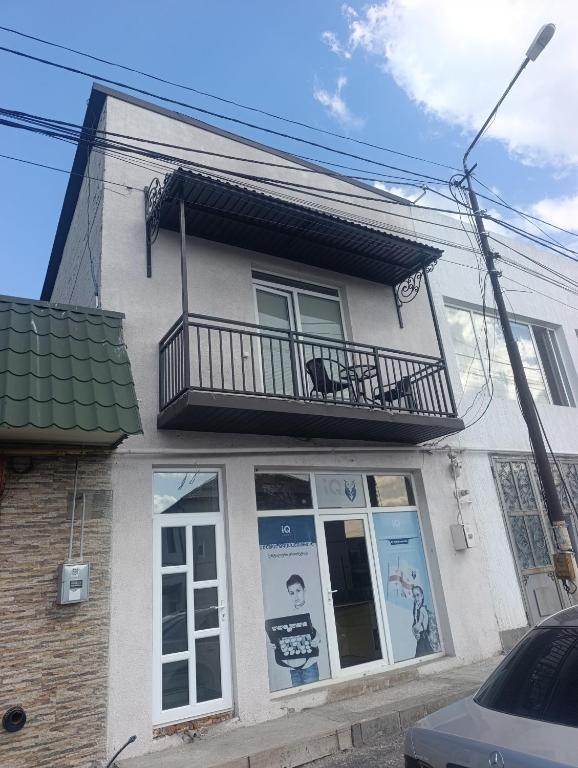 a white building with a balcony on top of it at VSt GRAND HOTEL in Ninotsminda