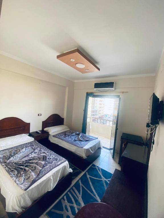 two beds in a room with a window at فندق الليدو in Marsa Matruh