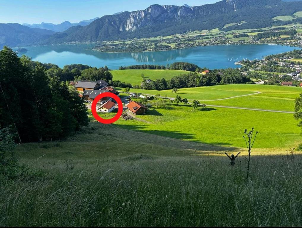 a red sign on a green field with a lake at Familienhof Kain in Tiefgraben