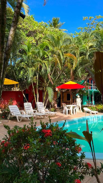 a resort with a swimming pool with chairs and umbrellas at Cajibá Imbassai in Imbassai