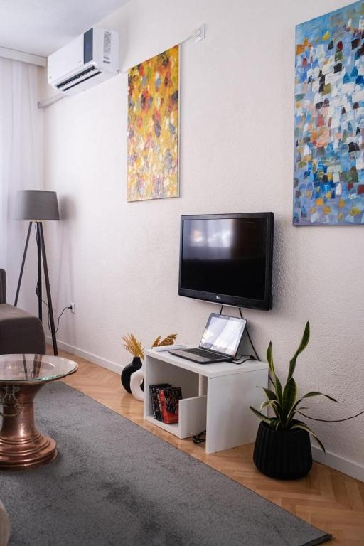 a living room with a television on a white cabinet at UrApartment in Prizren
