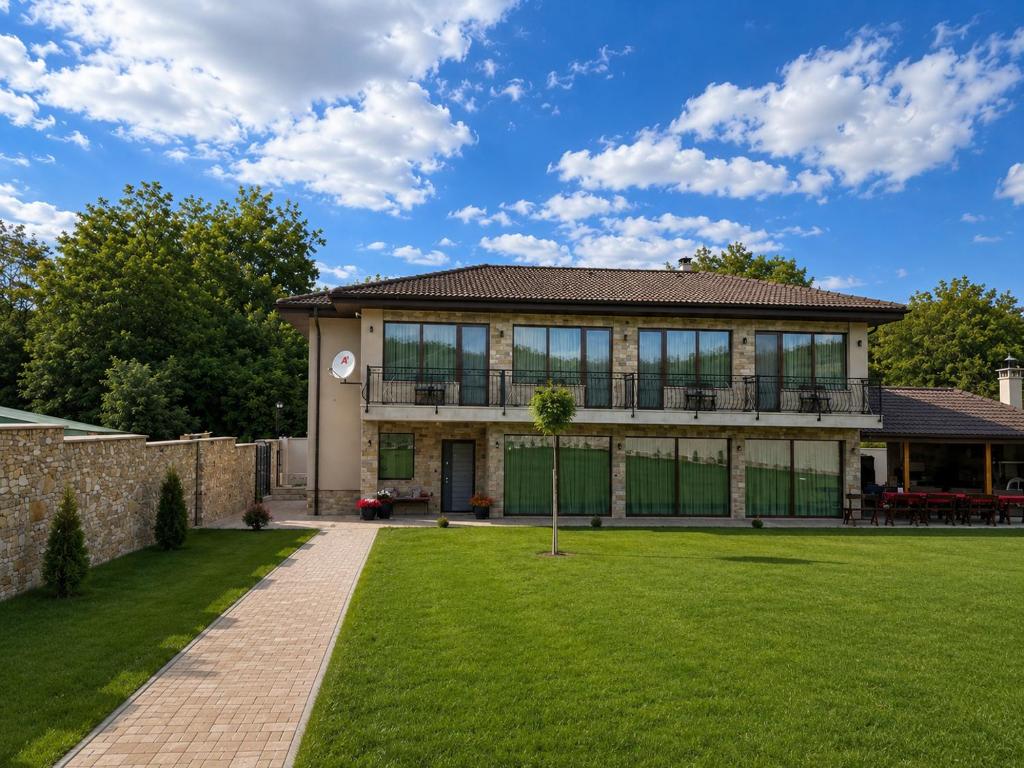 a large house with a lawn in front of it at Gracia House in Mogilovo
